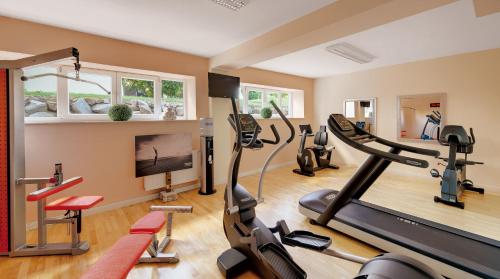 a gym with treadmills and cardio equipment in a room at Hotel Villa Medici in Bad Schonborn