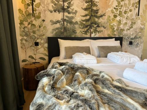 a bedroom with a bed with a fur blanket and pillows at Hello Pilis Apartments in Pilisszentkereszt