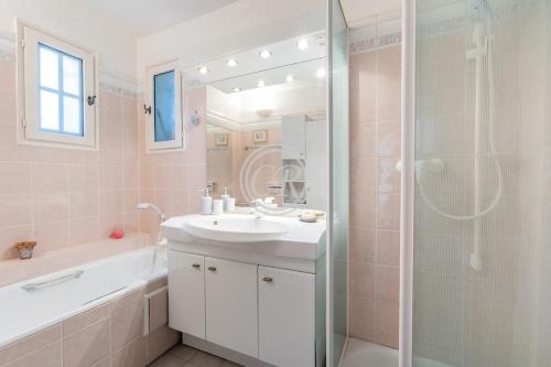une salle de bain blanche avec un lavabo et une douche dans l'établissement Provencal house with pool, à Bormes-les-Mimosas