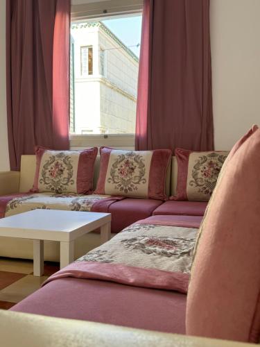 a living room with a couch and a window at joli appart avec terrasse au centre ville in Tetouan