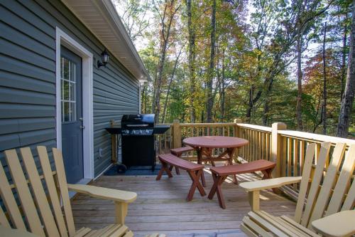 a porch with chairs and a table and a grill at BKs Hideaway in Pisgah Forest