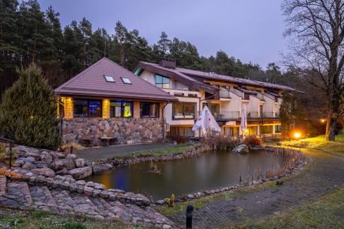 a house with a pond in front of it at Park Villa Hotel in Vilnius