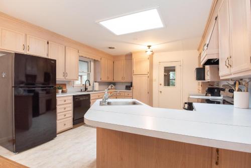 a kitchen with a sink and a black refrigerator at Inglewood Cottage in Saint Thomas