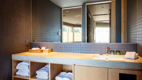 a bathroom with a sink and a mirror at HOTEL AO Kanazawa in Kanazawa