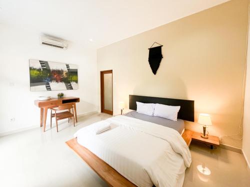 a bedroom with a large bed and a desk at Villa Kita Seminyak in Seminyak