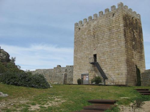 a large brick building with a staircase in it at Casa do Castelo de Celorico in Celorico da Beira