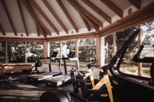 a gym with several treadmills and elliptical machines at Hotel Montis - Schönblick in Brunico