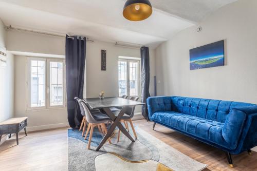 un salon avec un canapé bleu et une table dans l'établissement Appartement tout confort proche Vauban, à Marseille