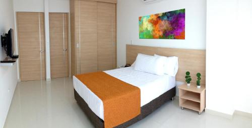 1 dormitorio con 1 cama y una pintura en la pared en Apartamento en Marbella, en Cartagena de Indias