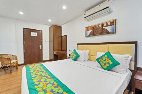 a bedroom with a large white bed with green and yellow pillows at Itsy Hotels Adrak in Trivandrum