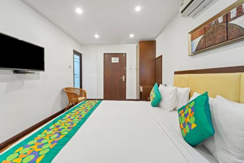 a bedroom with a large bed with a tv on the wall at Itsy Hotels Adrak in Trivandrum