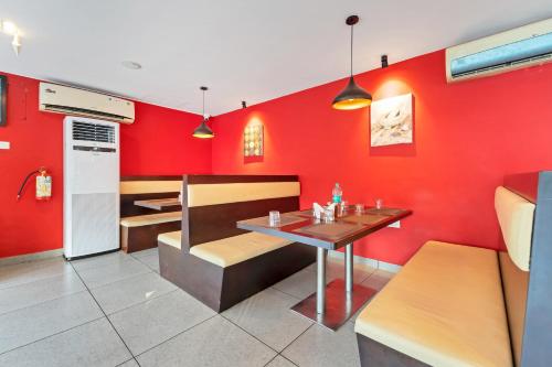 a restaurant with red walls and a table and benches at Itsy Hotels Adrak in Trivandrum