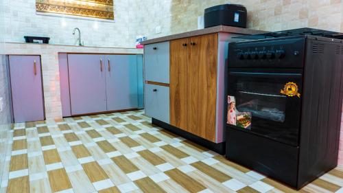 a kitchen with a stove and some purple cabinets at Opheboat Villa and Cuisine Services in Accra
