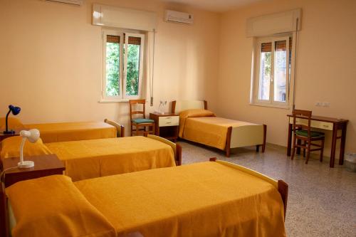 a hospital room with three beds and chairs and windows at Casa per ferie Maria Ausiliatrice in Rome