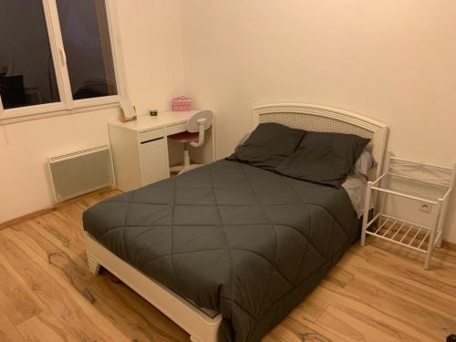 a bedroom with a bed and a desk and a window at Maison de Violette in Serrières-de-Briord