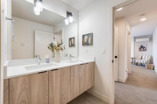 a bathroom with two sinks and a large mirror at Perch - View on Franklin in Seattle