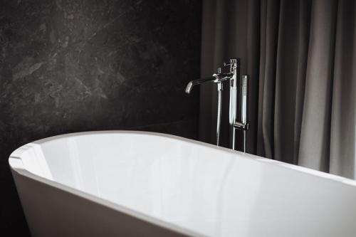 a white bath tub in a bathroom with a shower at Hotel Montis - Schönblick in Brunico