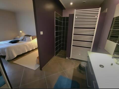 une chambre avec un lit et une salle de bain avec douche dans l'établissement Grande maison proche de la plage, à Barneville-Carteret