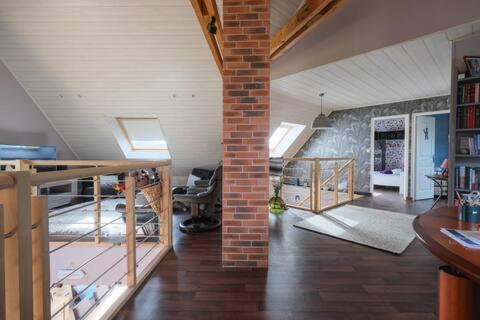 - un salon avec un mur en briques et un escalier dans l'établissement Grande maison proche de la plage, à Barneville-Carteret