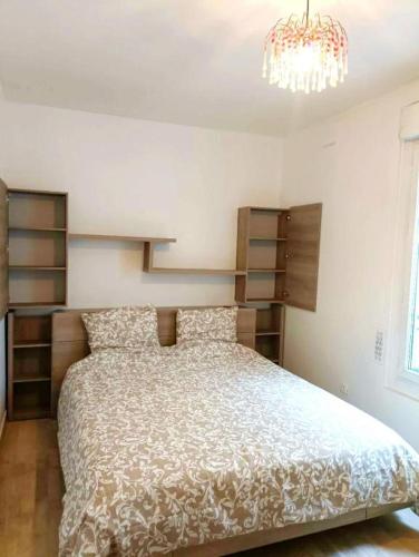 une chambre avec un lit et un lustre dans l'établissement Paris quiet cozy studio, à Paris