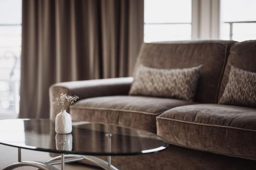 a living room with a couch and a glass coffee table at Hotel Montis - Schönblick in Brunico