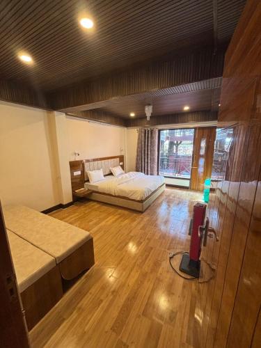 a room with two beds and a tv in it at Simla Hideaway in Shimla