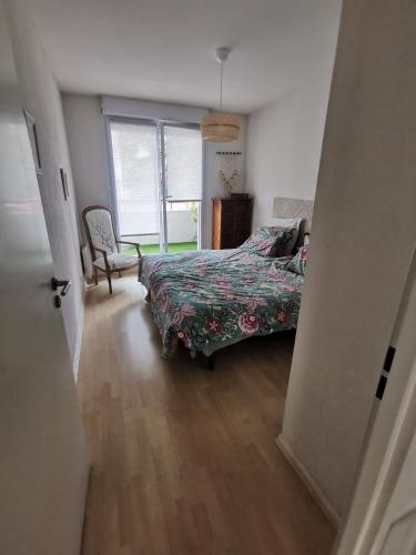 une chambre avec un lit, une chaise et une fenêtre dans l'établissement Le Gambetta, à Albi