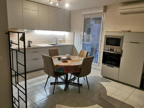 une cuisine avec une table et des chaises dans une pièce dans l'établissement Le Gambetta, à Albi