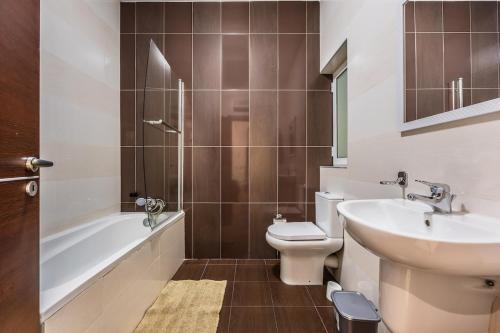 a bathroom with a sink and a toilet and a bath tub at Central Sliema Modern 2 bedroom Apartment Malta in Sliema