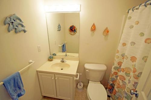 une salle de bain avec toilettes, lavabo et miroir dans l'établissement KD2035- The JPC Fisher, à Kill Devil Hills