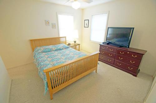 - une chambre avec un lit, une télévision et une commode dans l'établissement KD2035- The JPC Fisher, à Kill Devil Hills