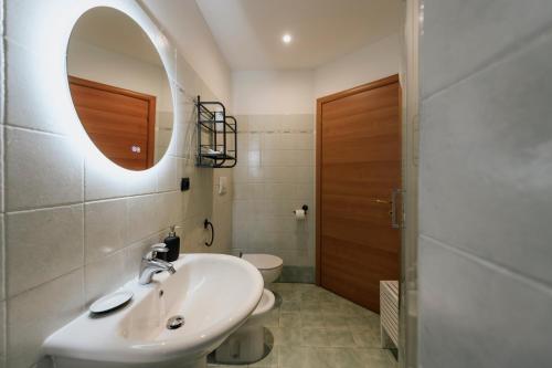 a bathroom with a sink and a mirror and a toilet at Ivrea Centro storico, 300m dal castello in Ivrea