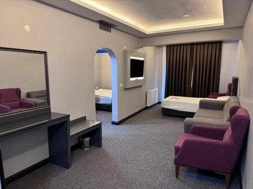 a hotel room with a tv and a bedroom at Gardan Hotel in Beylikduzu