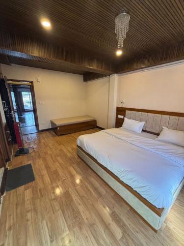 a bedroom with a large bed and a wooden floor at Simla Hideaway in Shimla