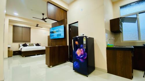 a living room with a refrigerator and a bedroom at Stay10 B&M LUXURY ACCOMDATION in Indore