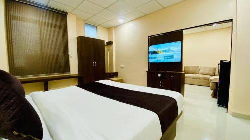 a bedroom with a bed and a flat screen tv at Stay10 B&M LUXURY ACCOMDATION in Indore