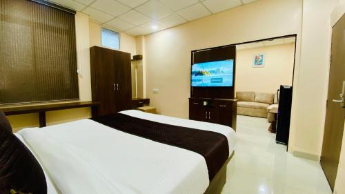 a bedroom with a bed and a flat screen tv at Stay10 B&M LUXURY ACCOMDATION in Indore