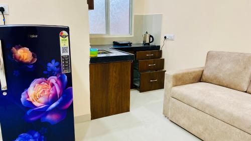 a kitchen with a refrigerator and a couch in a room at Stay10 B&M LUXURY ACCOMDATION in Indore