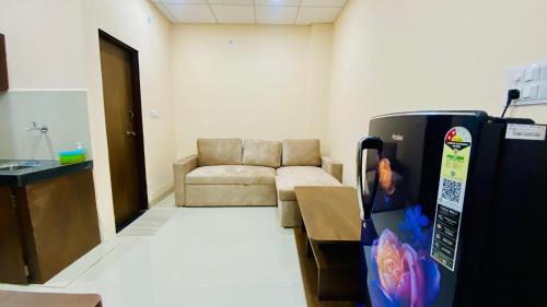 a living room with a couch and a refrigerator at Stay10 B&M LUXURY ACCOMDATION in Indore