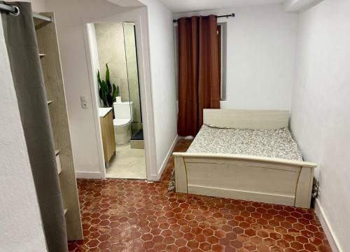 une petite chambre avec un lit et un miroir dans l'établissement Le cozy grasse, à Grasse