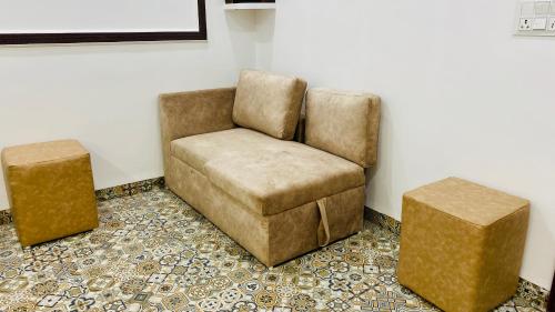a chair and a ottoman in a room at Stay10 B&M LUXURY ACCOMDATION in Indore