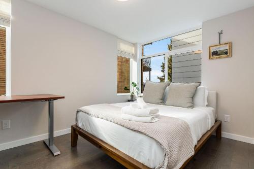 a bedroom with a bed with a desk and a window at Perch - Belmont Boutique 2 in Seattle