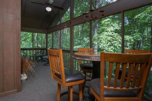 a screened in porch with a table and chairs at Peace of Heaven in Connestee in Brevard