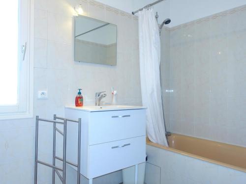 une salle de bain blanche avec un lavabo et une baignoire dans l'établissement Villa avec grand jardin et piscine privée, à Laroque-des-Albères