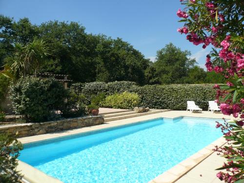 - une piscine dans un jardin fleuri dans l'établissement Villa avec grand jardin et piscine privée, à Laroque-des-Albères