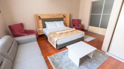 a bedroom with a bed and two chairs and a couch at Gardan Hotel in Beylikduzu