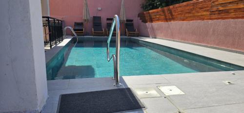 a swimming pool with a metal rail next to a building at Stellatos House in Póros Kefalonias