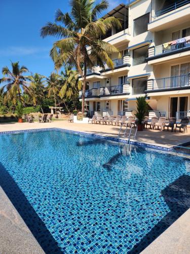 a swimming pool in front of a hotel at Beach Bliss Apartment Hotel - 7 Minutes walk to Beach in Colva