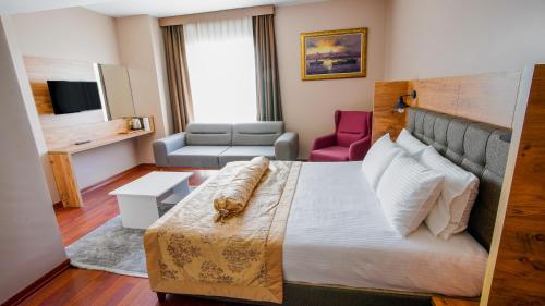 a hotel room with a large bed and a couch at Gardan Hotel in Beylikduzu