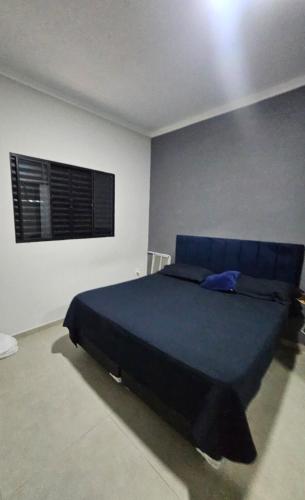 ein Schlafzimmer mit einem blauen Bett und einem Fenster in der Unterkunft Casa do Valença alugue no airbn in Tatuí